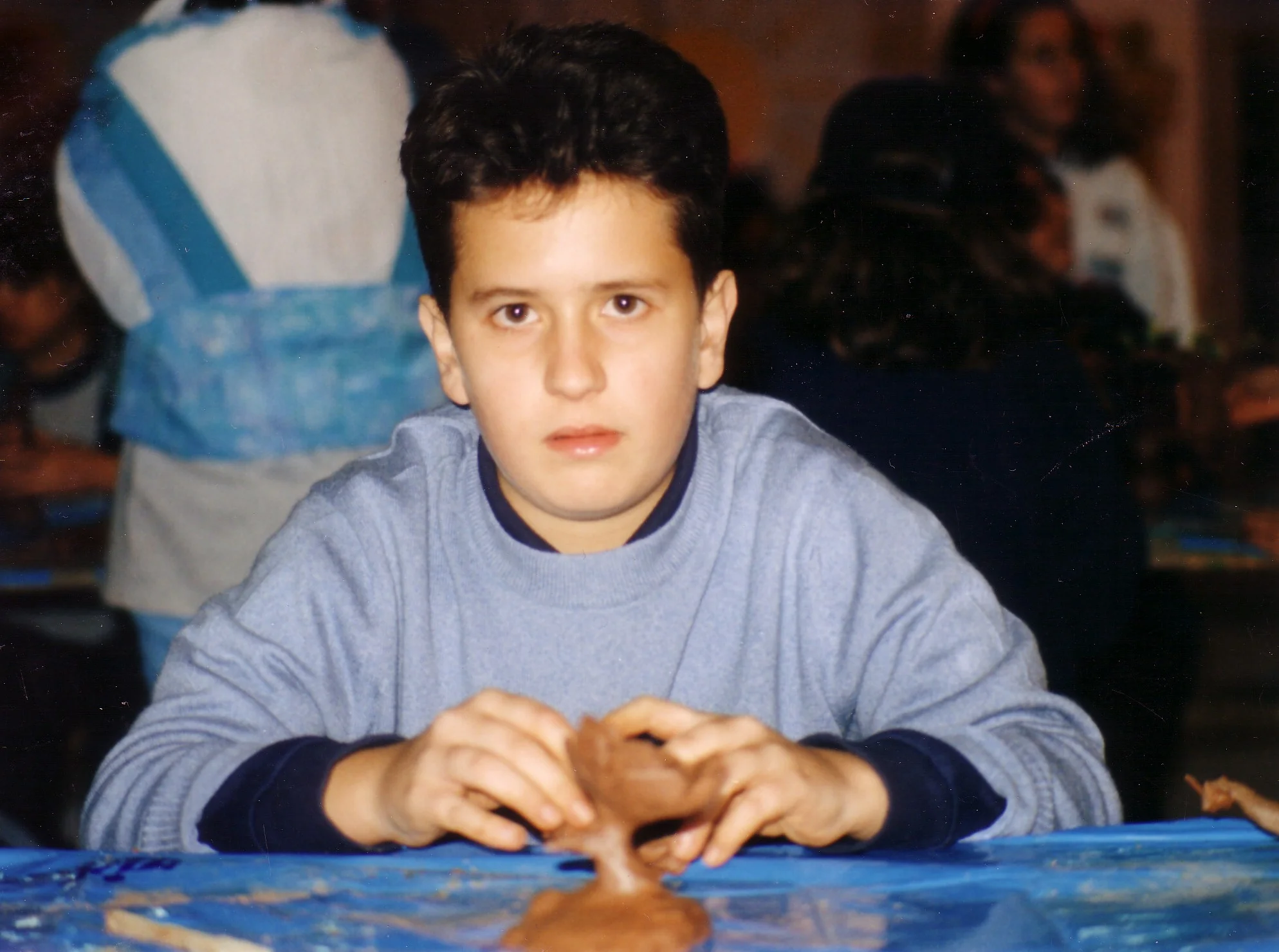 Alejandro as a child shaping clay
